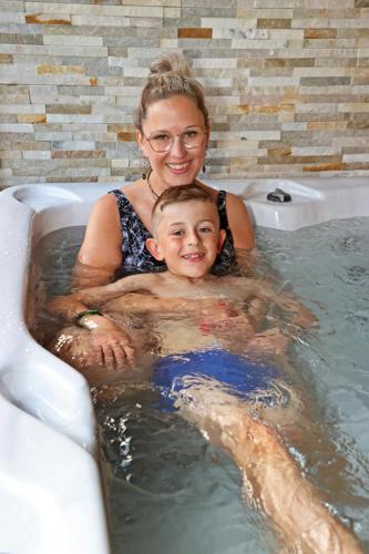 a woman and a boy in a bath tub at Potter's Place by Ardenne Places in Theux