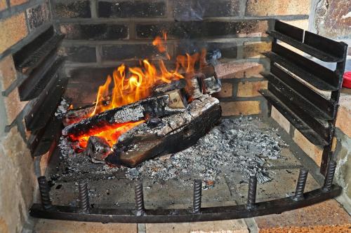 a fire in a brick fireplace with flames at Potter's Place by Ardenne Places in Theux