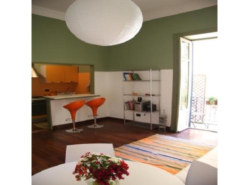 een woonkamer met een tafel en stoelen en een keuken bij Baru’s house in Palermo