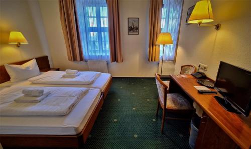 Habitación de hotel con 2 camas y escritorio con ordenador en Hotel Brander Hof, en Brand-Erbisdorf