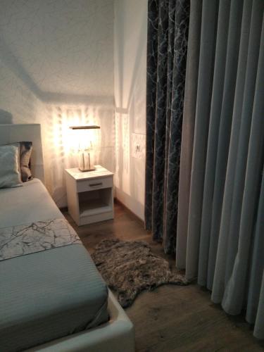 a bedroom with a bed and a table with a lamp at Harmony cozy home in Podgorica