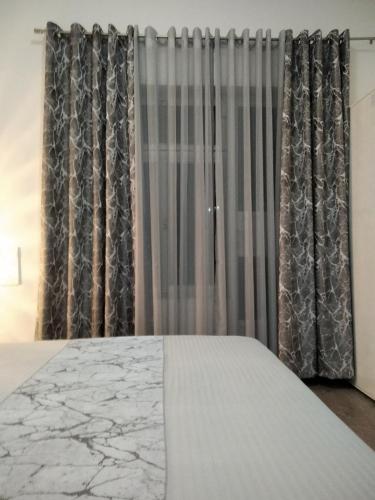 a bedroom with a bed and gray curtains at Harmony cozy home in Podgorica