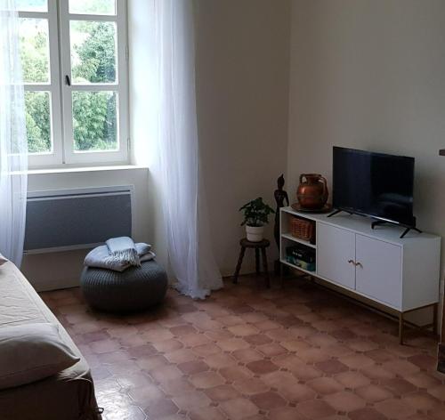 ein Wohnzimmer mit einem TV auf einem weißen Schrank in der Unterkunft Vista Cevenol: appartement 2 chambres in Saint-Jean-du-Gard