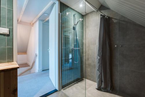 een badkamer met een douche en een glazen deur bij Vuurtorenveld 134 - Het Oude Nieuwland Ouddorp - NOT FOR COMPANIES in Ouddorp