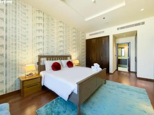 a bedroom with a large white bed with red pillows at bnbmehomes - Look over the Palm and Sea from Every Room - 504 in Dubai