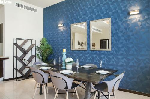 a dining room with a blue wall with mirrors at bnbmehomes - Tiara Tanzanite in Dubai