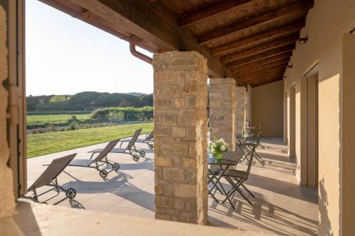 an outdoor patio with chairs and a table with a view at Casa vacanze Le Querce in Castiglione della Pescaia