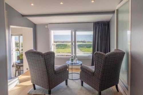 a living room with two chairs and a table and a window at Hôtel Atalante - Relais Thalasso & Spa in Sainte-Marie-de-Ré