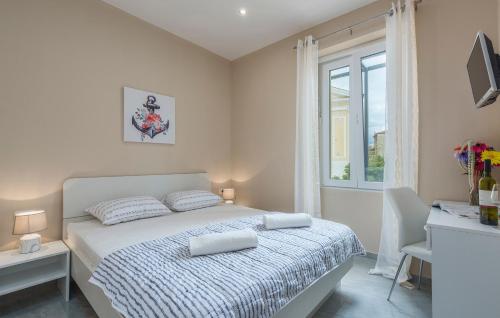 a white bedroom with a bed and a window at Roberto rooms in Poreč