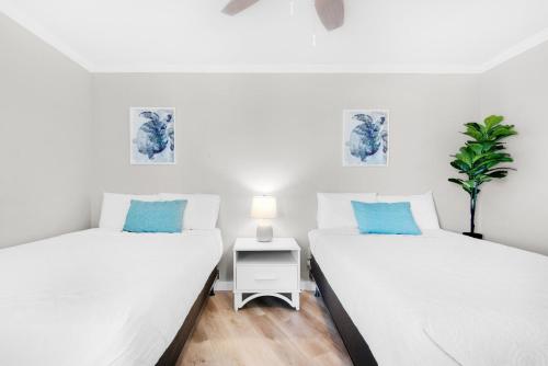2 Einzelbetten in einem Zimmer mit einer Pflanze in der Unterkunft Edgewater Tower 2-408 in Panama City Beach