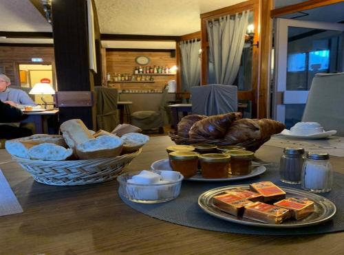 una mesa con pan y otros alimentos. en Hotel Valérie en Montgenèvre