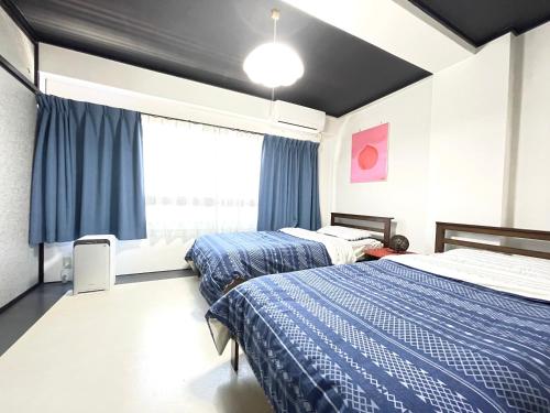 1 dormitorio con 2 camas y ventana en Beppu Story - Family Room 3 -, en Beppu