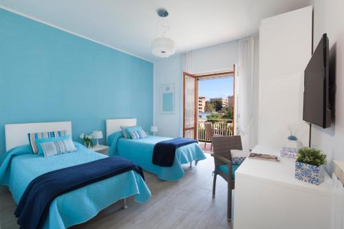 ソレントにあるEstate4home - Casa Rosangelaの青いベッドルーム(ベッド2台、テレビ付)
