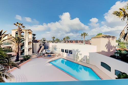 a swimming pool in front of a building with palm trees at Imperial Beach Club in Imperial Beach