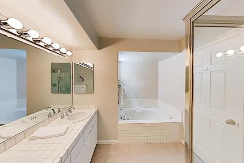Un baño con dos lavabos y una bañera. en Imperial Beach Club Unit 303 Oceanfront condo, direct beach access, pool, hot tub, & private balcony, en Imperial Beach