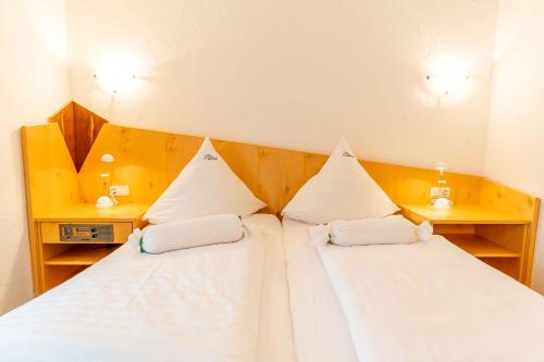 a bedroom with two beds and two night stands at Hotel Alpenhof in Bad Wörishofen