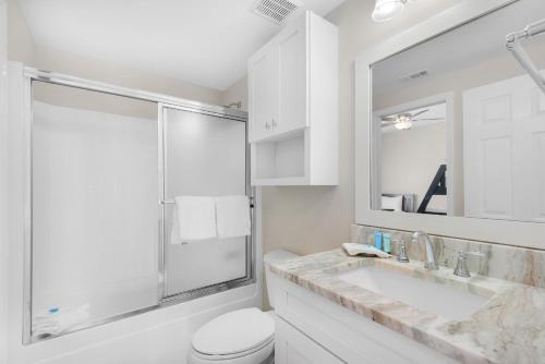 a white bathroom with a toilet and a sink at Sandpiper Cove 4114 in Destin