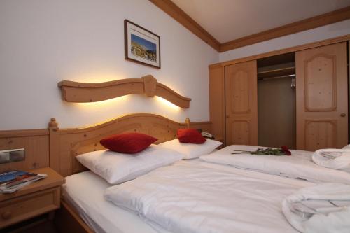 a bedroom with two beds with red pillows on them at Gast- und Ferienhof Christler in Tux