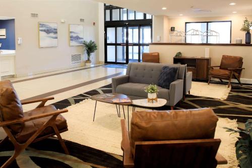 a living room with a couch and chairs and a table at Baymont by Wyndham Jackson/Ridgeland in Jackson