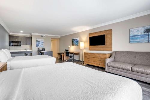 a hotel room with a bed and a couch at The Encinitan Hotel & Suites in Encinitas