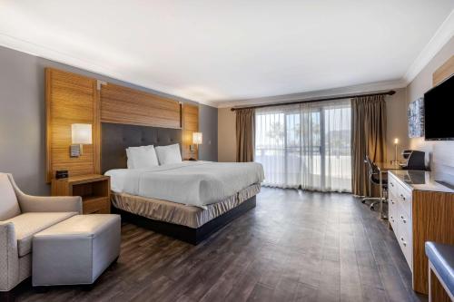 Habitación de hotel con cama y TV en The Encinitan Hotel & Suites en Encinitas