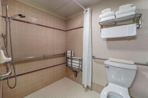a bathroom with a toilet and a shower and towels at Comfort Inn Humboldt Bay in Eureka
