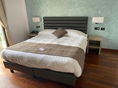 a bedroom with a large bed with two night stands at Hotel Parigi & Spa in Bordighera