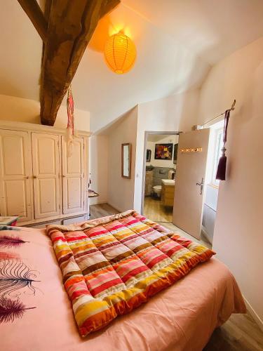 a bedroom with a bed with a colorful blanket on it at Studio le moulin de Pascale in Espelette