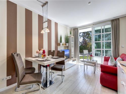 - un salon avec une table et un canapé rouge dans l'établissement Residenz am Balmer See - BS 04 mit Wellnessbereich, à Balm