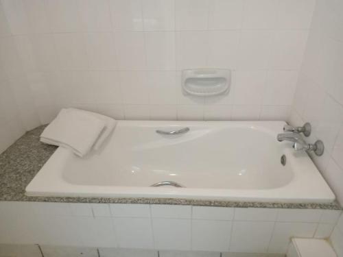 a white sink in a white tiled bathroom at Turtle Bay Beach Club- All Inclusive in Watamu