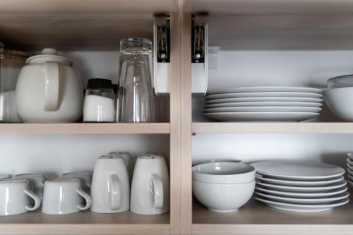 a cupboard filled with plates and bowls and dishes at Apartmány Janka + camp in Bešeňová