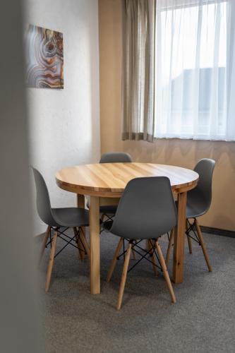 a wooden table with four chairs around it at Apartmány Janka + camp in Bešeňová