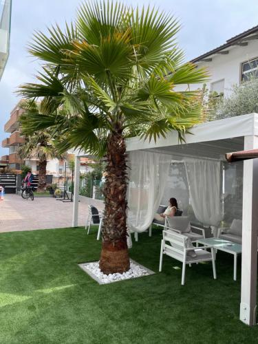 un palmier devant une tente avec une femme dans l'établissement Exclusive Home 1, à Misano Adriatico