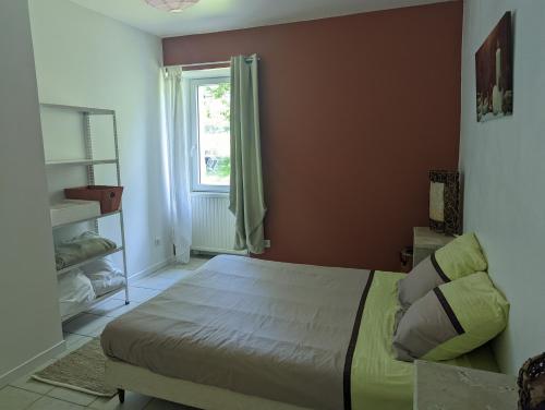 una camera da letto con un letto e una finestra di Gîte de Maran 1 - Le Nid Douillet a Gaugeac