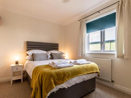 a bedroom with a bed with towels on it at Pass the Keys Stylish holiday townhouse by the Quay with parking in Exeter