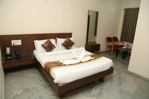 a hotel room with a bed with towels on it at Soundarya Hotel in Bengaluru