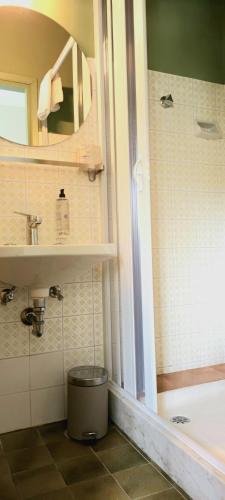 a bathroom with a tub and a sink and a mirror at Hotel Millepini in Marina Romea