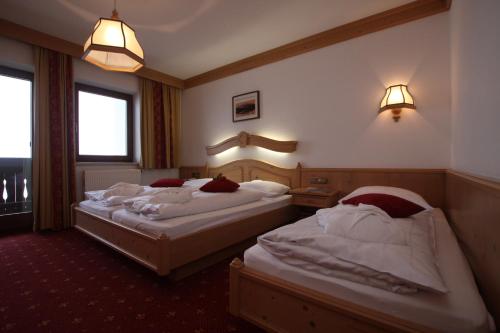 a hotel room with two beds and a window at Gast- und Ferienhof Christler in Tux