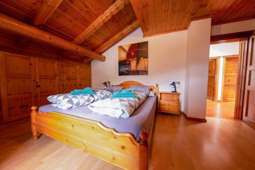 a bedroom with a bed in a room with wooden ceilings at Appartamenti Valeria 1 in Livigno