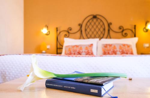 a book sitting on top of a table next to a bed at Hotel Baglio Di Scopello in Scopello