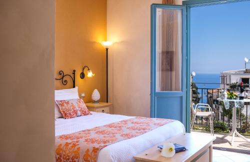 a bedroom with a bed and a view of the ocean at Hotel Baglio Di Scopello in Scopello