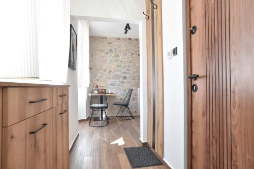 a hallway leading to a kitchen with a brick wall at Sambra old town apartment in Budva