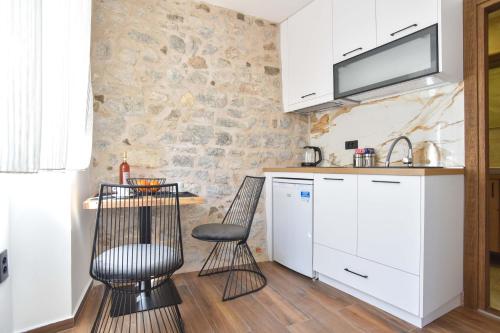 a kitchen with white cabinets and a table and chairs at Sambra old town apartment in Budva