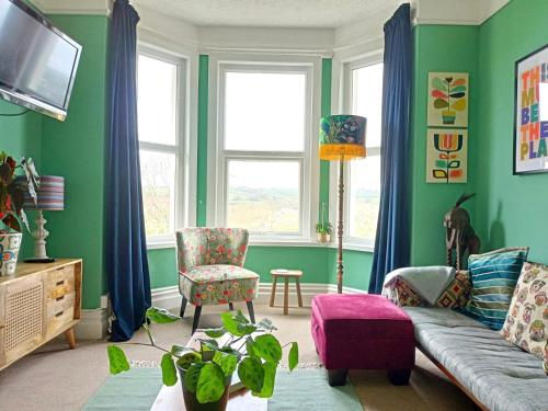 sala de estar con paredes verdes y sofá en Unique 2-bedroom Coastal Town Retreat en Kingsbridge