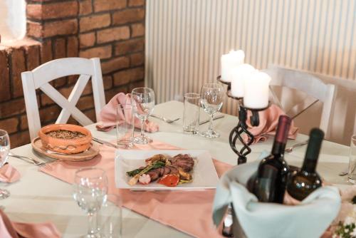 a table with a plate of food and wine bottles at Vinceia in Smederevo