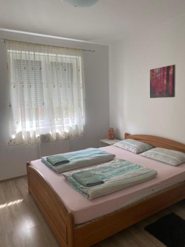 1 Schlafzimmer mit 2 Betten und einem Fenster in der Unterkunft Belle Casa 24 in Debrecen