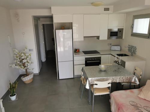a kitchen with a table and a kitchen with white cabinets at Divino en playa in Granadilla de Abona