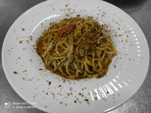 a plate of pasta on a plate with a fork at Hotel La Fattoria Sul Mare in Capo Vaticano