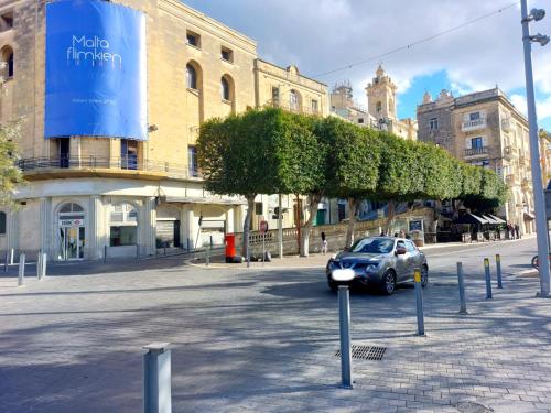 a car parked in a parking lot in front of a building at Casa Birmula Boutique Hotel in Cospicua