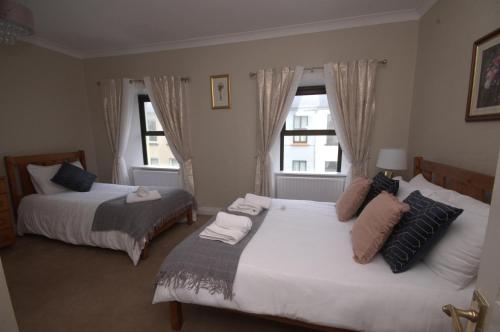 a bedroom with two beds and a window at Lizzys Little Kitchen Town Accommodation in Listowel